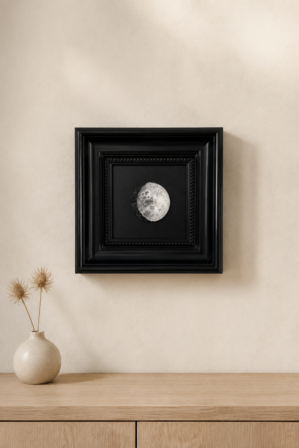 Personalized moon phase artwork hanging above a wooden console